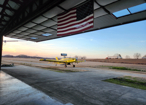 Airplane Hangar with Agricultural Plane Outside and American Flag