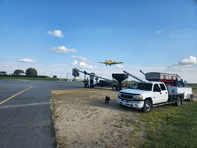 Airport Auger Truck with Plane Flying Overhead